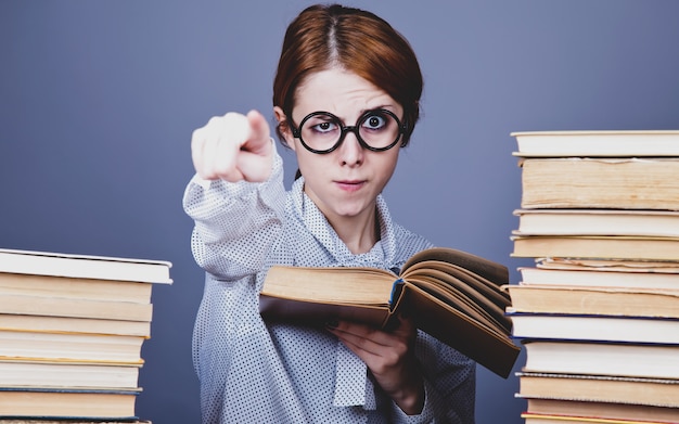 Le jeune enseignant à lunettes avec des livres.