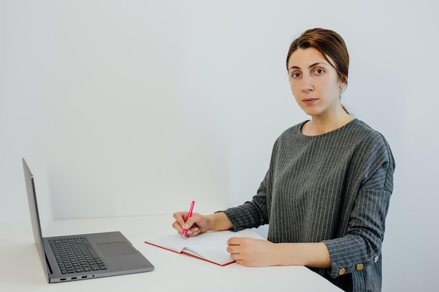 Un jeune enseignant utilise un ordinateur portable pour apprendre écrit des informations utiles regarde la caméra et parle di ...