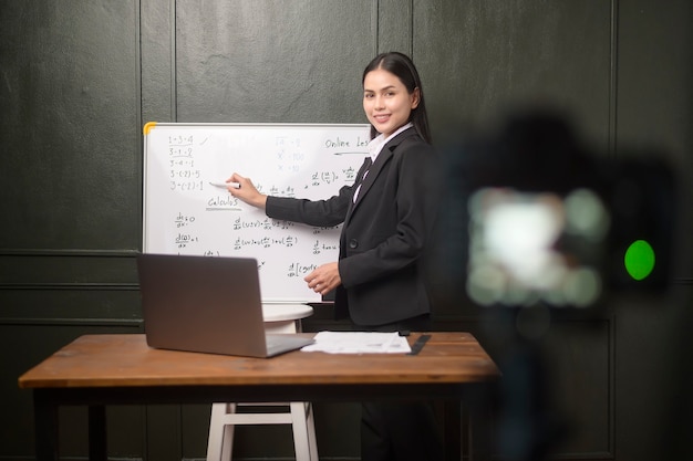 Une jeune enseignante utilise une caméra pour enregistrer une leçon en ligne pendant la quarantaine, l'éducation en ligne, le concept d'apprentissage à distance.