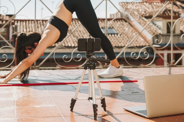 Photo une jeune entraîneure en forme sportive donne des cours en ligne par appel vidéo sur son téléphone portable