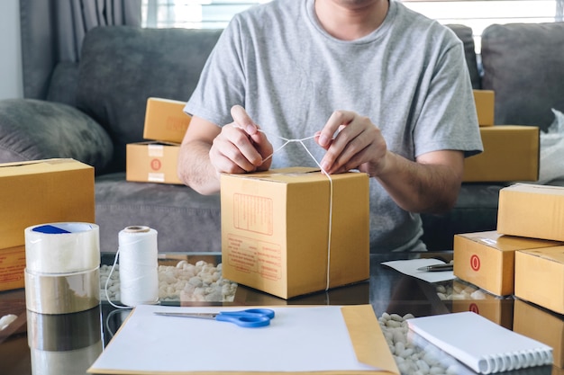 Un Jeune Entrepreneur, Un Homme De Pme Reçoit Un Client Qui Commande Et Travaille Avec Le Marché En Ligne De La Distribution De Boîtes De Tri Sur Le Bon De Commande