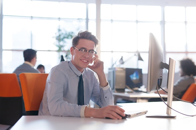 Jeune entrepreneur indépendant travaillant à l'aide d'un ordinateur dans un espace de coworking