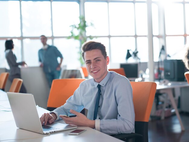 Jeune entrepreneur indépendant travaillant à l'aide d'un ordinateur portable dans un espace de coworking