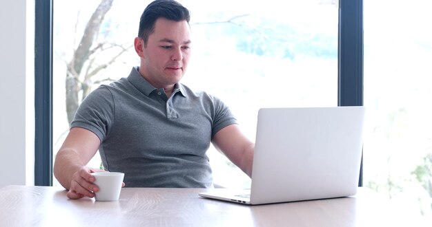 Jeune entrepreneur indépendant travaillant à l'aide d'un ordinateur portable dans un espace de coworking