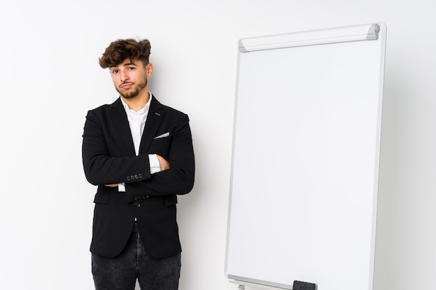 Jeune entreprise coaching homme arabe malheureux à la recherche à huis clos avec une expression sarcastique.