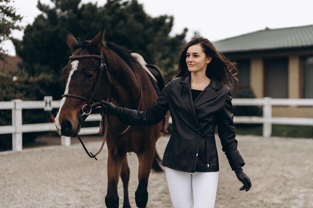 Un jeune équestre en uniforme pose avec une belle photo de haute qualité de cheval majestueux