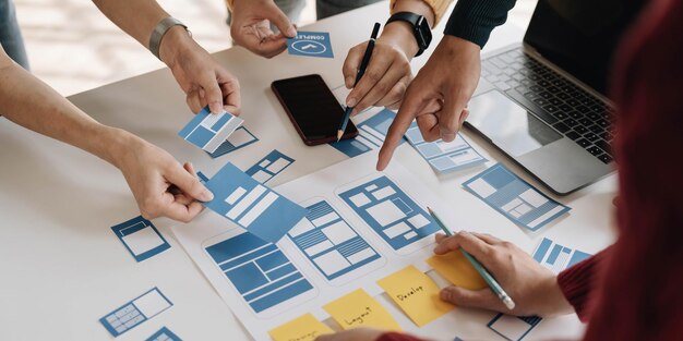 Jeune équipe créative d'entreprises asiatiques travaille ensemble projet de conception de logiciels d'applications mobiles réunion de brainstorming technologie Internet smartphone concepteur d'applications Web bureau collègue de travail concept de travail en équipe