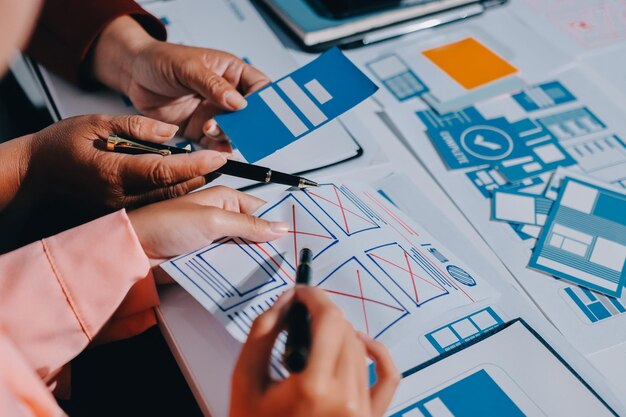 Jeune équipe créative d'entreprises asiatiques travaille ensemble projet de conception de logiciels d'applications mobiles réunion de brainstorming technologie Internet smartphone concepteur d'applications Web bureau collègue de travail concept de travail en équipe