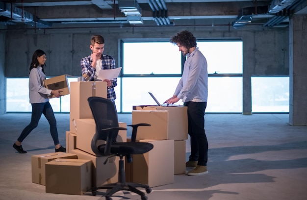 jeune équipe de gens d'affaires en groupe, architecte et ingénieur sur le chantier de construction vérifiant les documents et le flux de travail d'entreprise à l'aide d'un ordinateur portable dans le nouveau bureau de démarrage