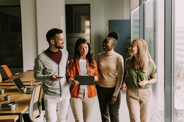 Une jeune équipe de start-up multiethnique se promène dans le bureau moderne