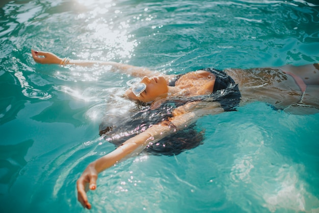 Jeune est relaxant dans une piscine