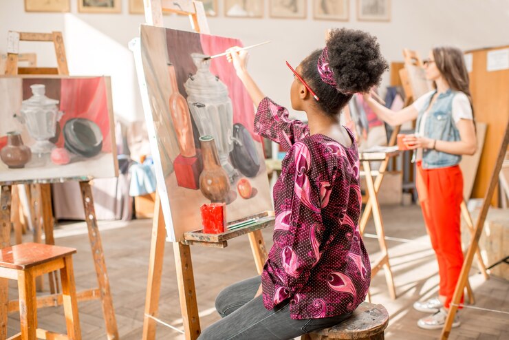 Photo jeune étudiant africain peignant la peinture de nature morte au studio