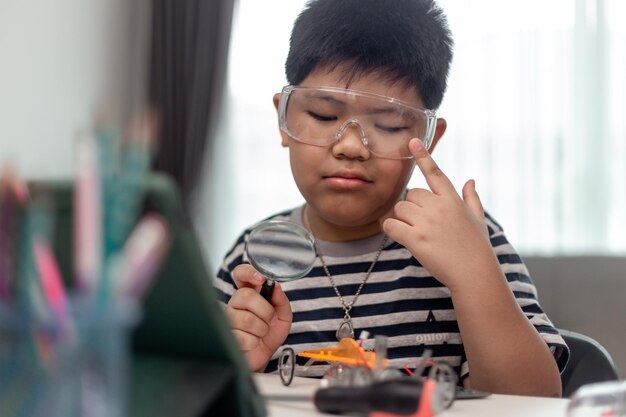 Un jeune étudiant asiatique apprend à distance en ligne à la maison à coder des voitures robotiques et des câbles électroniques en STEM STEAM mathématiques ingénieur science technologie code informatique en robotique pour les enfants