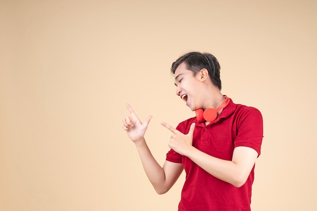 Jeune étudiant asiatique beau et joyeux avec le geste de la main