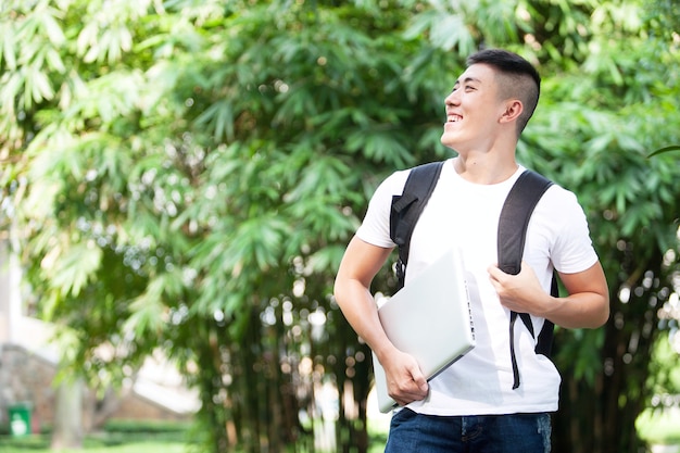 Jeune étudiant asiatique beau en plein air dans le parc