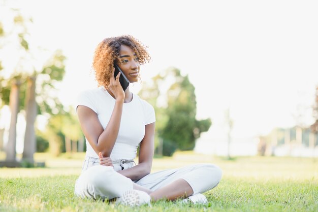 Jeune étudiant assis sur la pelouse