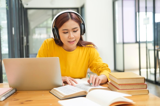 Jeune étudiant en collage utilisant un ordinateur et un appareil mobile étudiant en ligne