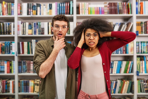 Jeune étudiant Avec Expression Inquiète Dans Une Bibliothèque