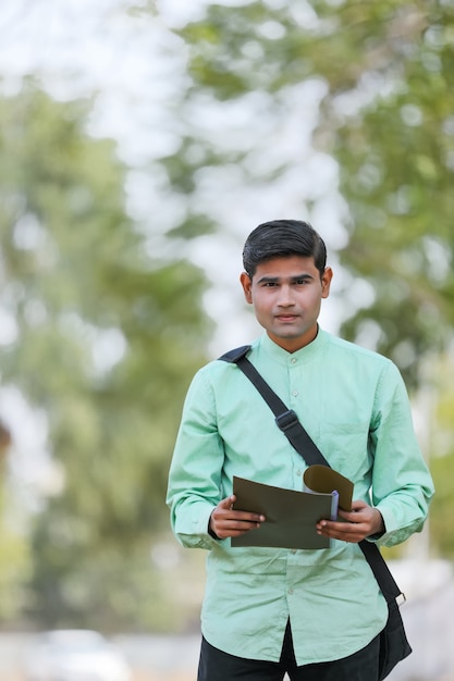 Jeune étudiant indien ou chercheur d'emploi tenant le fichier en main.