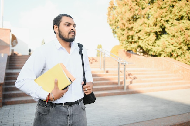 Jeune étudiant indien transportant des livres