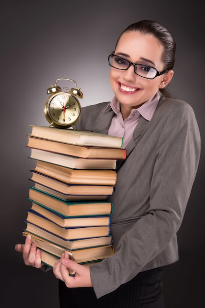 Jeune étudiant avec des livres et une horloge