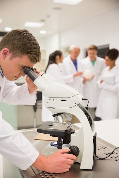 Jeune étudiant en médecine travaillant avec un microscope