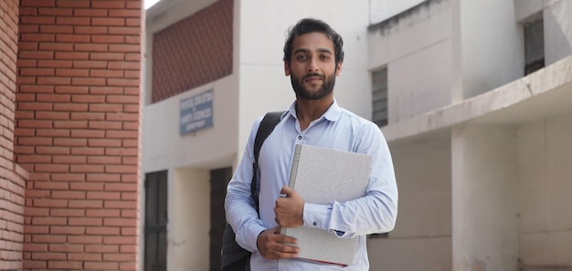 Jeune étudiant avec ordinateur portable sur le campus universitaire