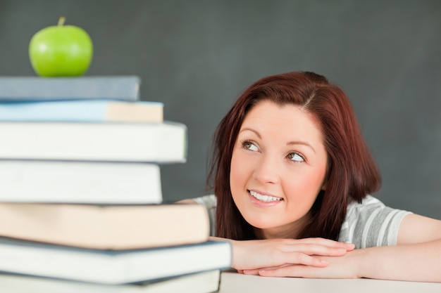 Jeune étudiant en regardant la pomme sur le dessus de ses livres