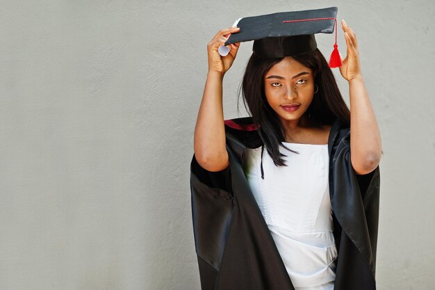 Jeune étudiante afro-américaine avec diplôme pose à l'extérieur.