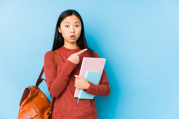 Jeune étudiante asiatique femme pointant vers le côté