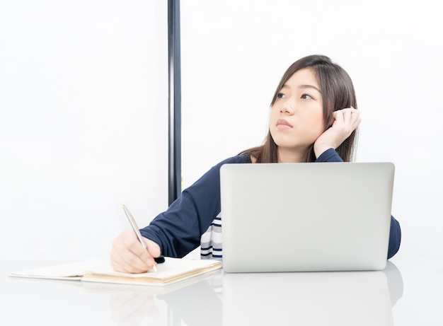 Jeune étudiante assise dans le salon et apprendre en ligne