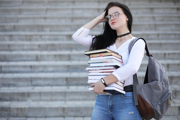 Jeune étudiante dans la rue avec un sac à dos et des livres