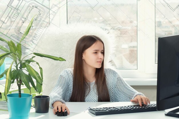 Une jeune étudiante engagée dans des dessins apprend à concevoir en ligne