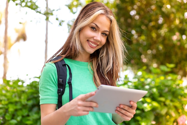 Jeune étudiante à l'extérieur tenant une tablette