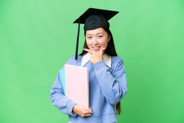 Jeune étudiante femme sur fond isolé chroma key heureux et souriant