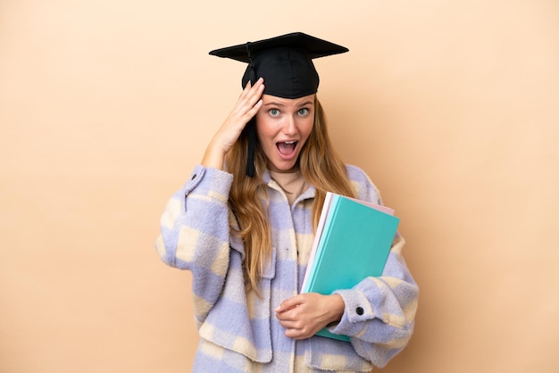 Jeune étudiante sur fond isolé avec une expression de surprise