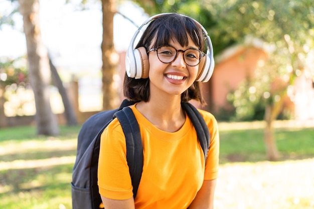 Une jeune étudiante gagne un parc en écoutant de la musique