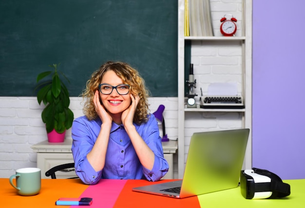 Une jeune étudiante heureuse pense aux cours d'un professeur d'université en classe