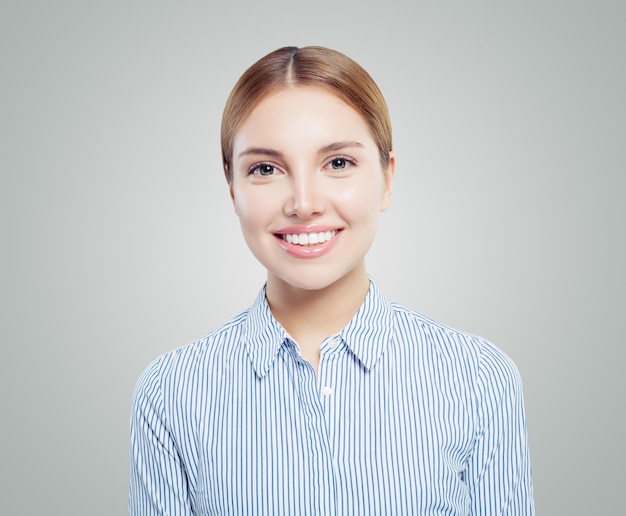 Une jeune étudiante heureuse souriant sur un fond blanc.