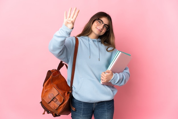 Jeune étudiante isolée sur rose heureux et comptant quatre avec les doigts