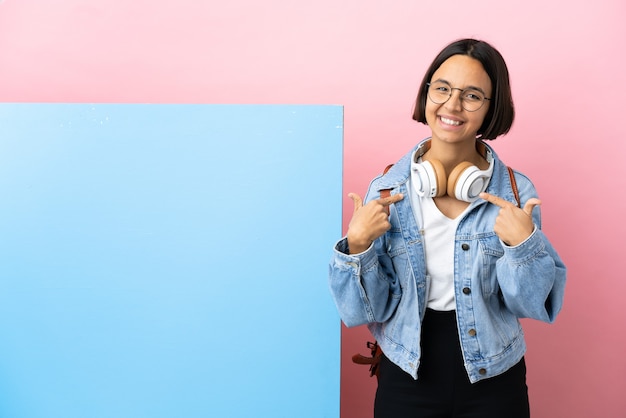 Jeune étudiante métisse femme avec une grande bannière sur fond isolé fier et satisfait de lui-même