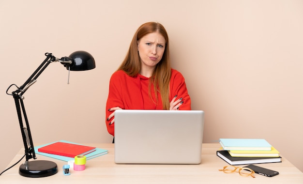 Jeune étudiante en milieu de travail avec un ordinateur portable se sentant bouleversé