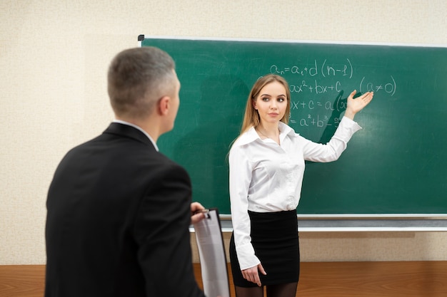 Jeune étudiante passe un examen près du tableau noir.