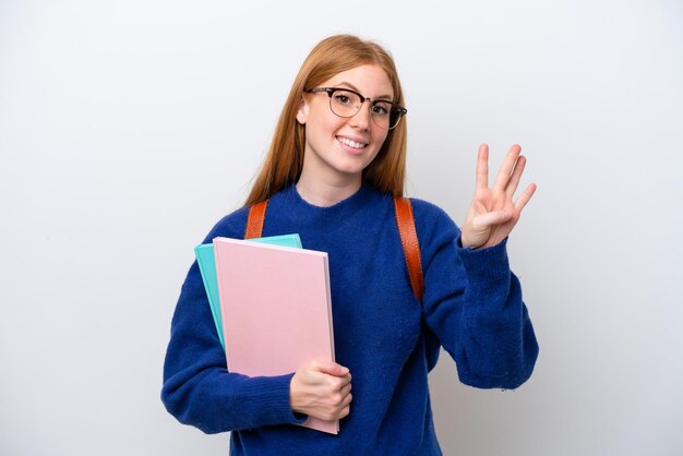 Jeune étudiante rousse femme isolée sur fond blanc heureuse et comptant quatre avec les doigts