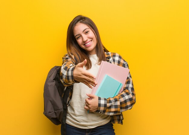 Jeune étudiante tendre la main pour saluer quelqu'un