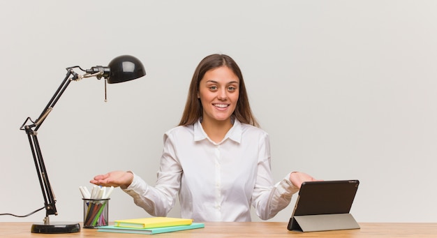 Jeune étudiante travaillant sur son bureau et invitant à venir