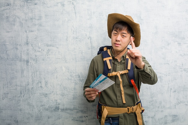 Jeune explorateur chinois tenant un billet d&#39;avion montrant le numéro un