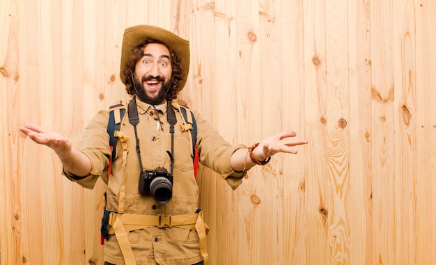 Jeune explorateur fou avec chapeau de paille et sac à dos sur mur en bois