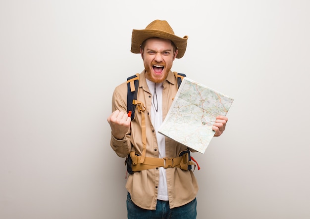 Jeune explorateur rousse surpris et choqué Tenant une carte.