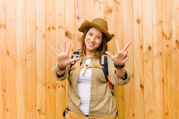 Jeune exploratrice latine femme contre bois